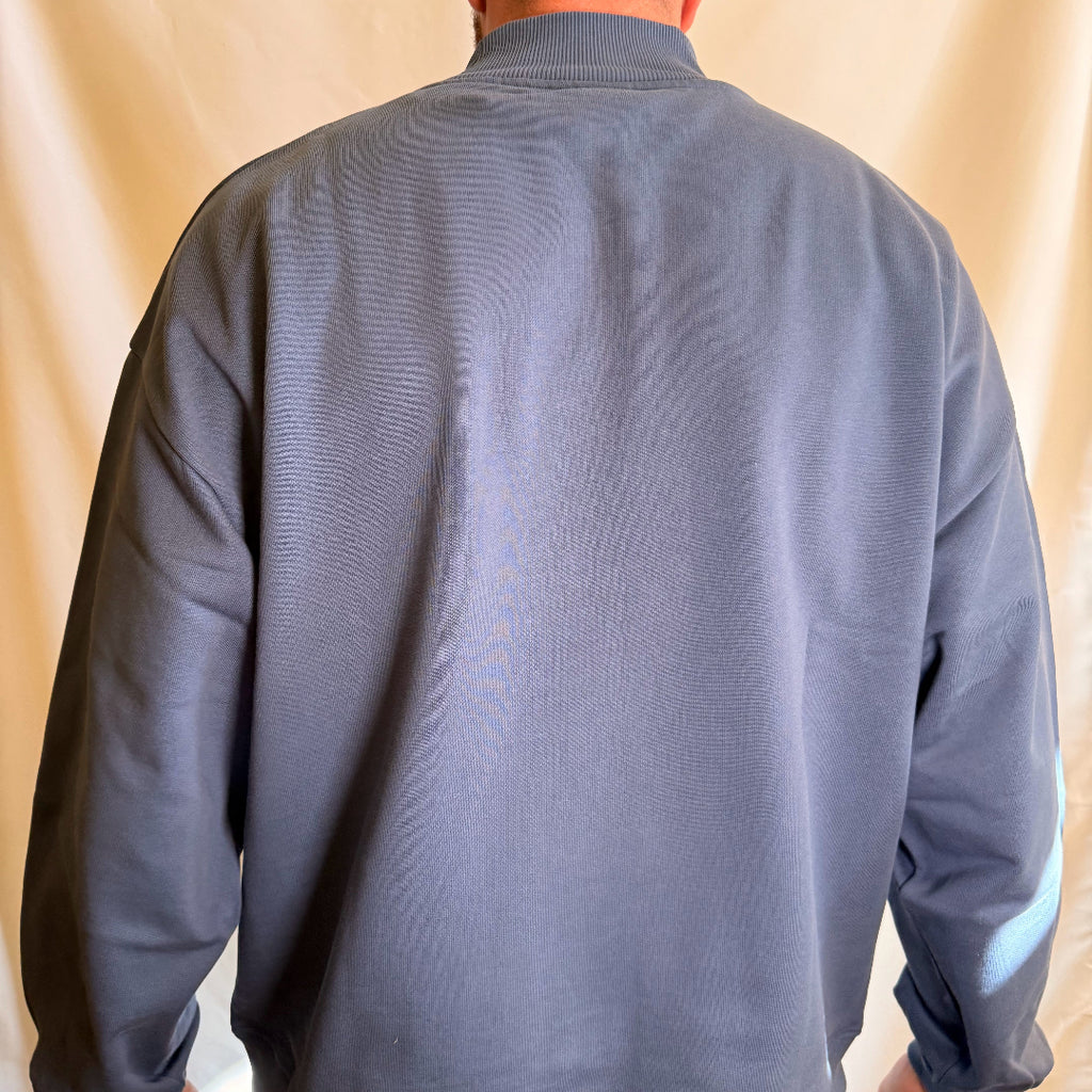 IRBN mock neck sweatshirt in Blue Indigo — back view showing oversized fit and ribbed mock neck, worn in XXL