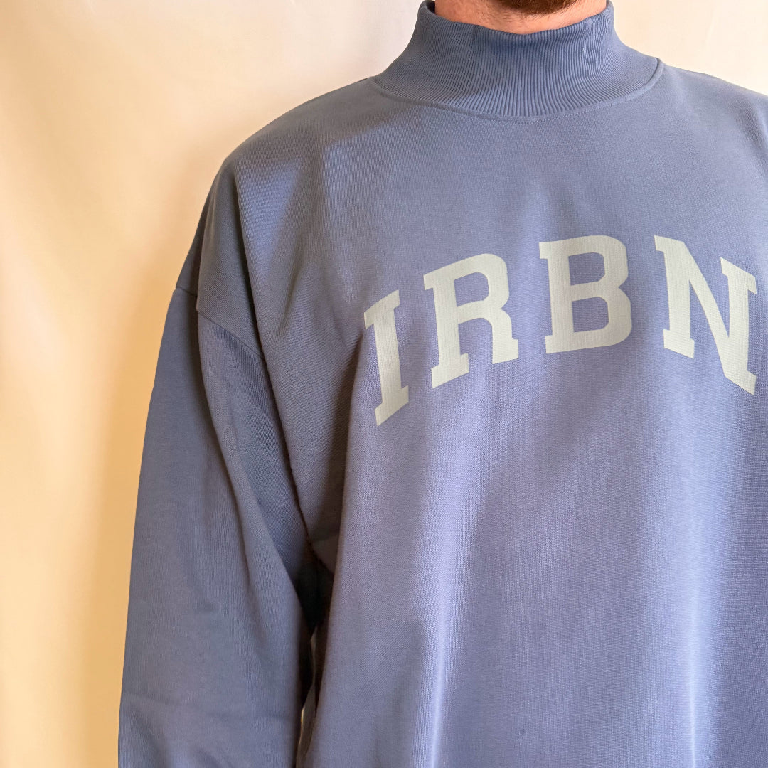 IRBN mock neck sweatshirt in Blue Indigo — front chest detail showing tonal IRBN arch print, worn in XXL