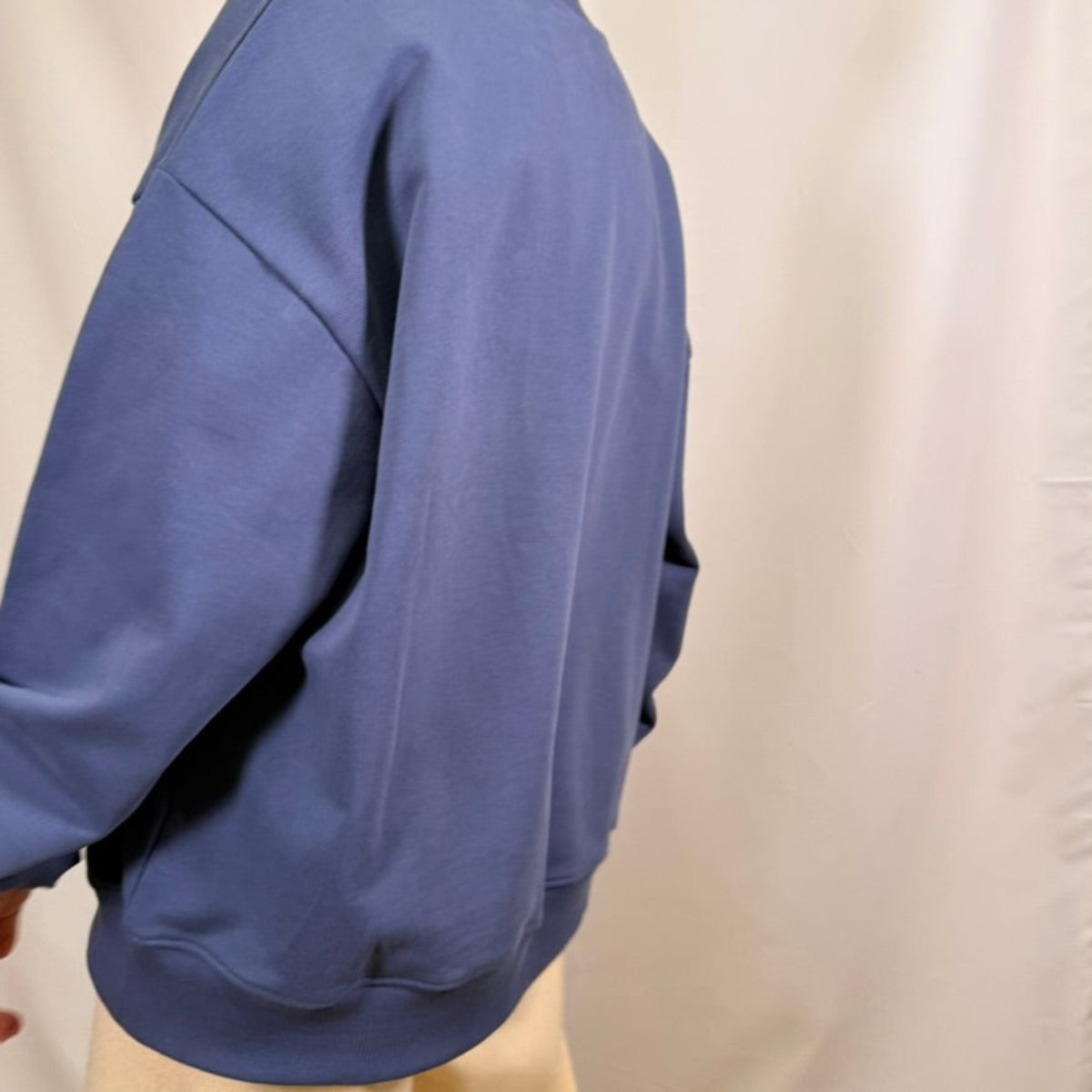 IRBN mock neck sweatshirt in Blue Indigo, side-back view showing oversized sleeve and ribbed hem, 400gsm organic cotton