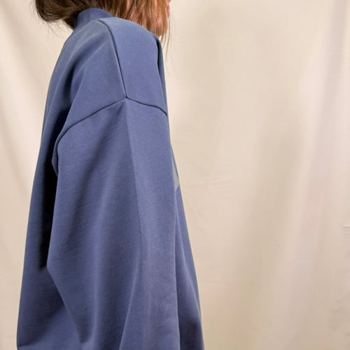 IRBN mock neck sweatshirt in Blue Indigo, side view showing boxy silhouette and ribbed cuff, 400gsm organic cotton