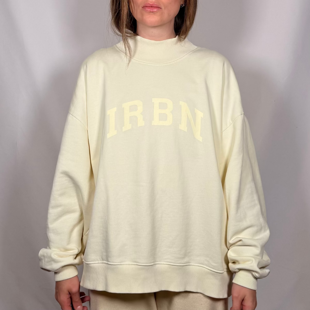 IRBN mock neck sweatshirt in Cannoli Cream, front view showing IRBN arched print and ribbed mock neck collar