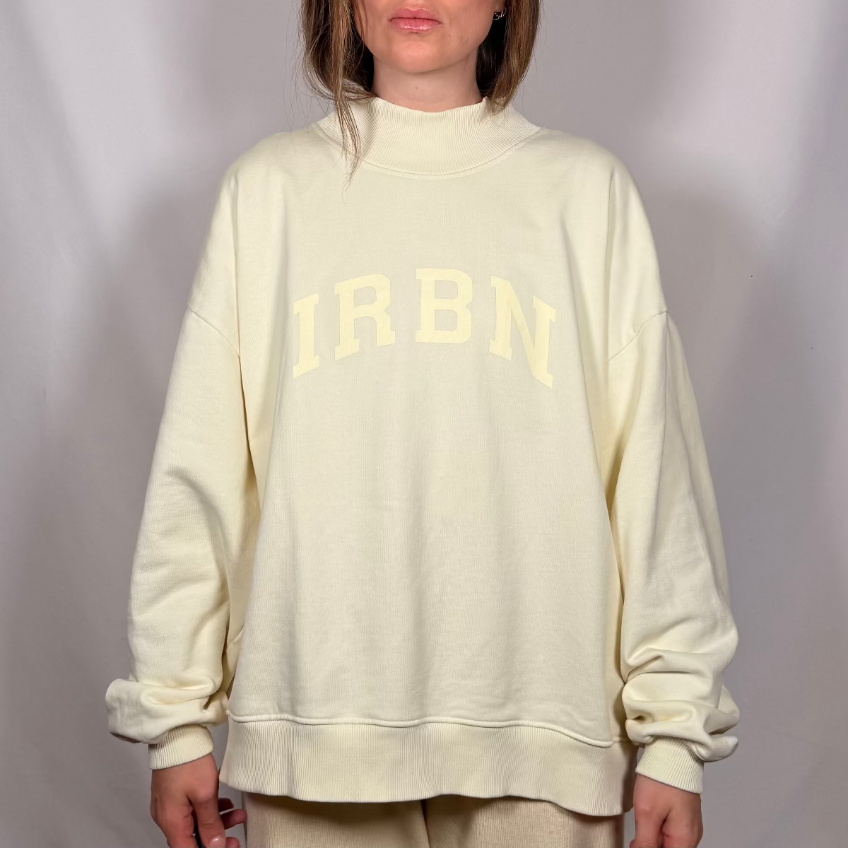 IRBN mock neck sweatshirt in Cannoli Cream, front view showing IRBN arched print and ribbed mock neck collar