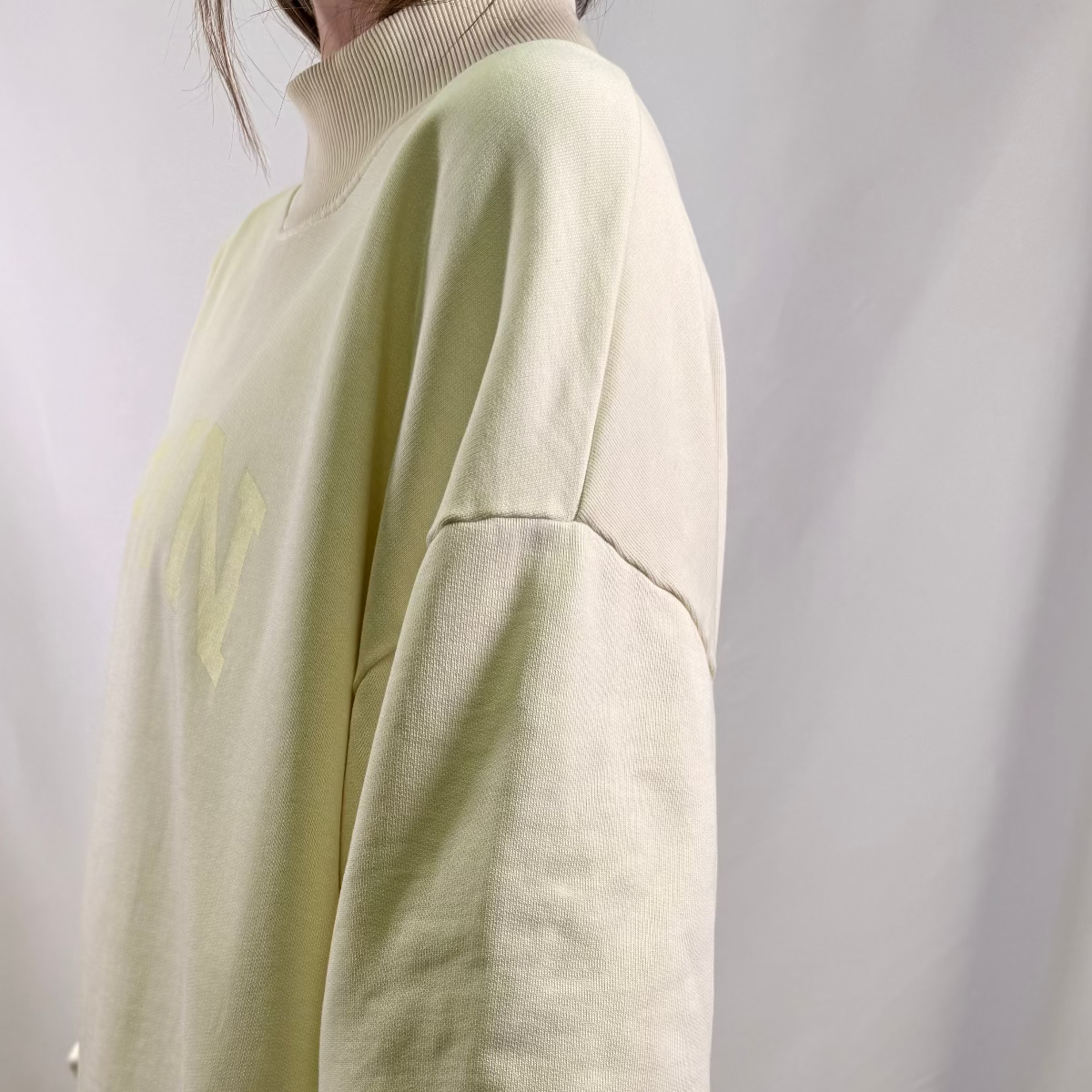 IRBN mock neck sweatshirt in Cannoli Cream, side view showing boxy fit and ribbed cuff, 400gsm organic cotton