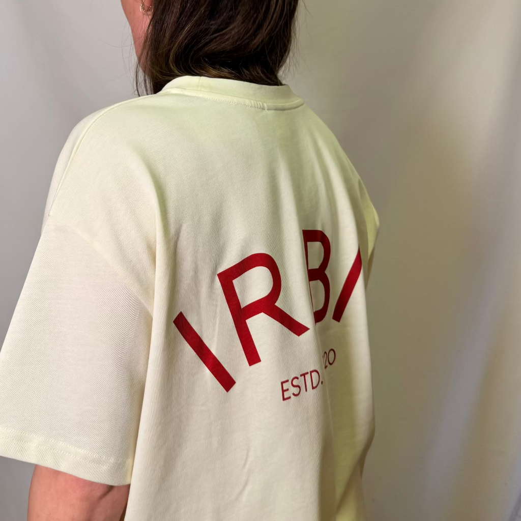IRBN boxy t-shirt in Cannoli Cream, back view showing IRBN ESTD. 2020 arched print in red, 250gsm organic cotton