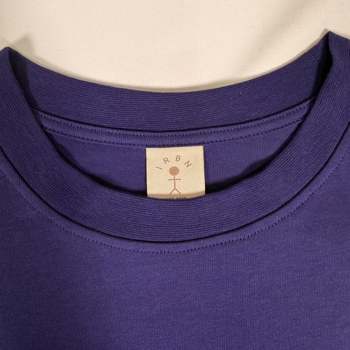 Close-up of woven IRBN neck label on Navy boxy t-shirt, GOTS-certified organic cotton made in Portugal